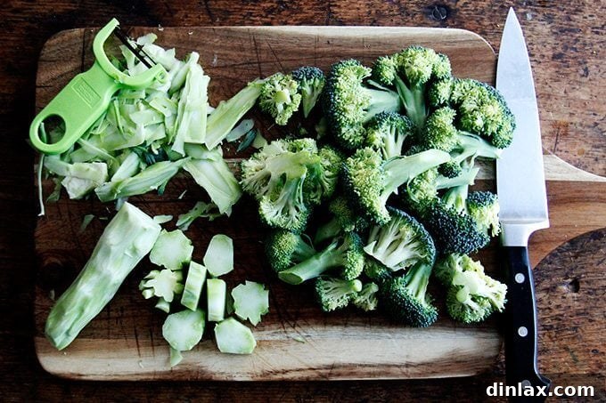 Golden Tofu and Broccoli with Savory Peanut Sesame Pesto 3 Fresh broccoli being prepared: florets are cut, and the thick stems are peeled and sliced into rounds, ready for roasting.