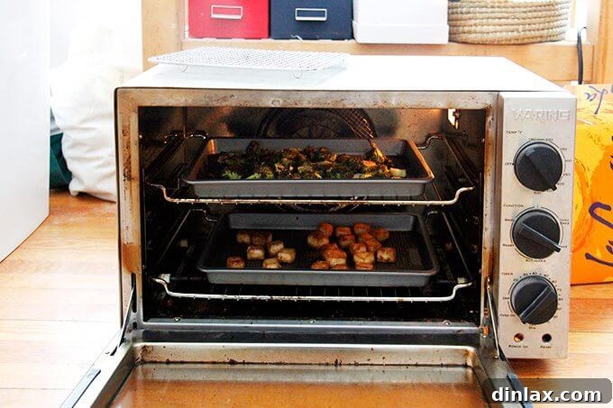 Golden Tofu and Broccoli with Savory Peanut Sesame Pesto 6 Tofu and broccoli roasting on separate sheet pans in a hot oven, gradually turning golden brown and tender.