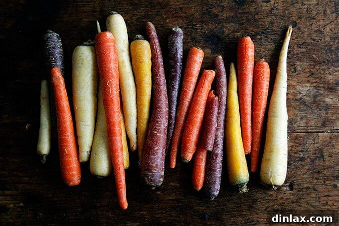 A cutting board filled with an array of multi-colored carrots, ready for preparation.