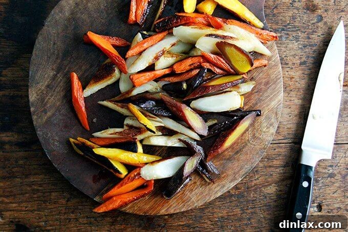 Sliced roasted carrots arranged on a cutting board, cut into uniform half-inch thick pieces at a sharp angle.