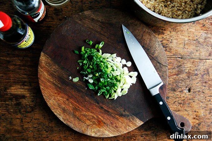 Your Ultimate Instant Pot Brown Rice: Perfect and Flavorful 9 A cutting board with fresh scallions and a knife, ready for slicing.