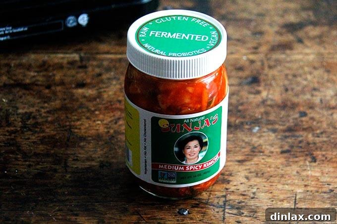 A jar of Sunja kimchi, displaying its vibrant colors and fresh ingredients, sits ready for use.