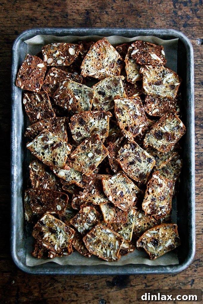 Three Seed Crisps 17 Freshly baked, golden-brown, and perfectly crisp three-seed crackers cooling on a sheet pan, just removed from the oven.