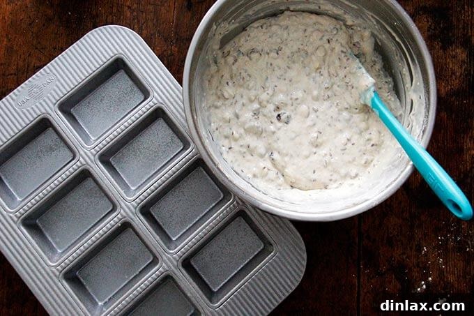 Three Seed Crisps 9 A greased 8-compartment mini loaf pan is placed next to the fully mixed batter for the three-seed crackers, ready for filling.