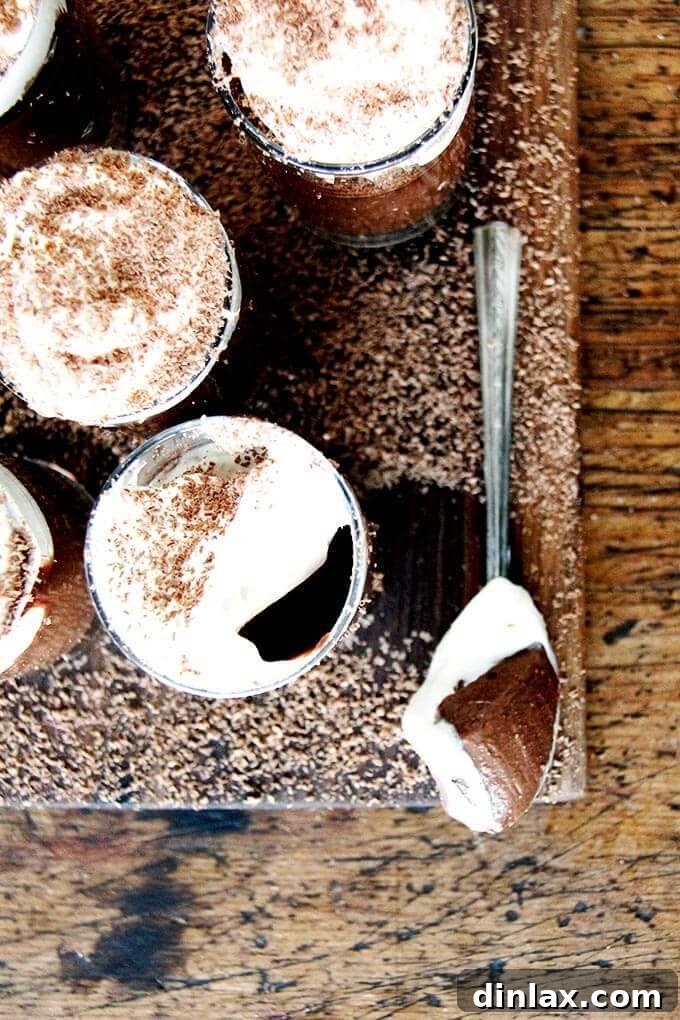 Overhead shot of pots de creme on a board aside a spoon. 