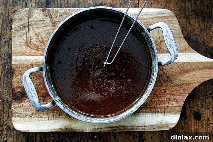 An overhead shot of a pot holding the pot de creme mixture with a whisk inside. 