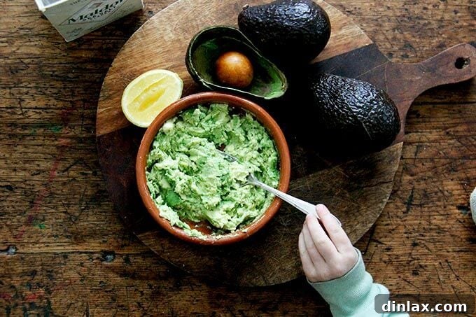 Mashed avocado in a bowl, mixed with lemon and salt.