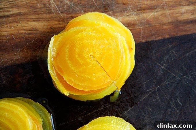 Stacked, thinly sliced beets on a cutting board, ready for forming.