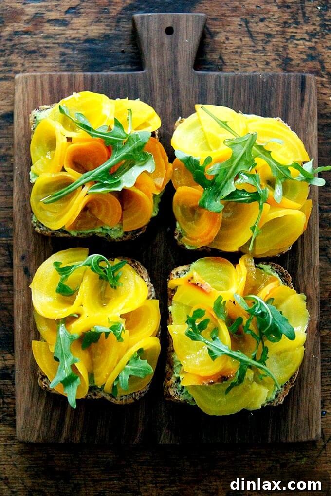 Avocado toasts topped with beet roses and a sprinkle of fresh arugula, with a drizzle of olive oil.