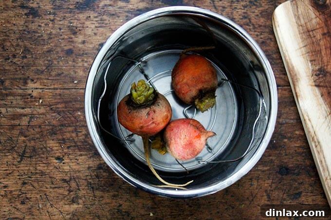 An Instant Pot containing three golden beets, ready for cooking.