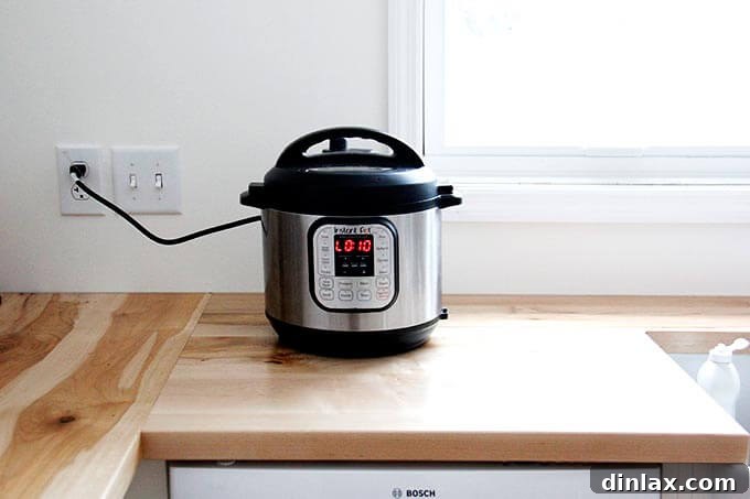 Instant pot on the counter, actively cooking with steam indicator visible.