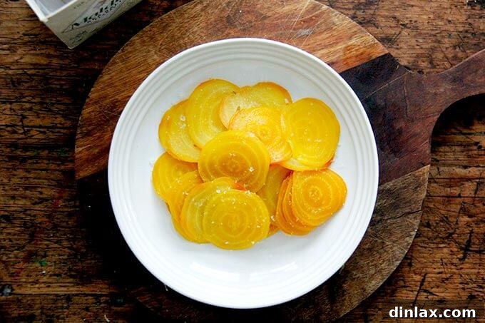 Sliced beets in a bowl, generously seasoned with salt.