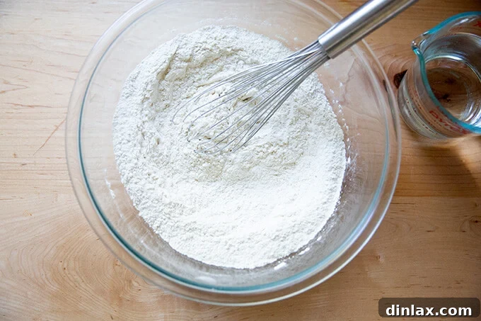 A bowl with dry ingredients for focaccia (flour, salt, yeast) whisked together.
