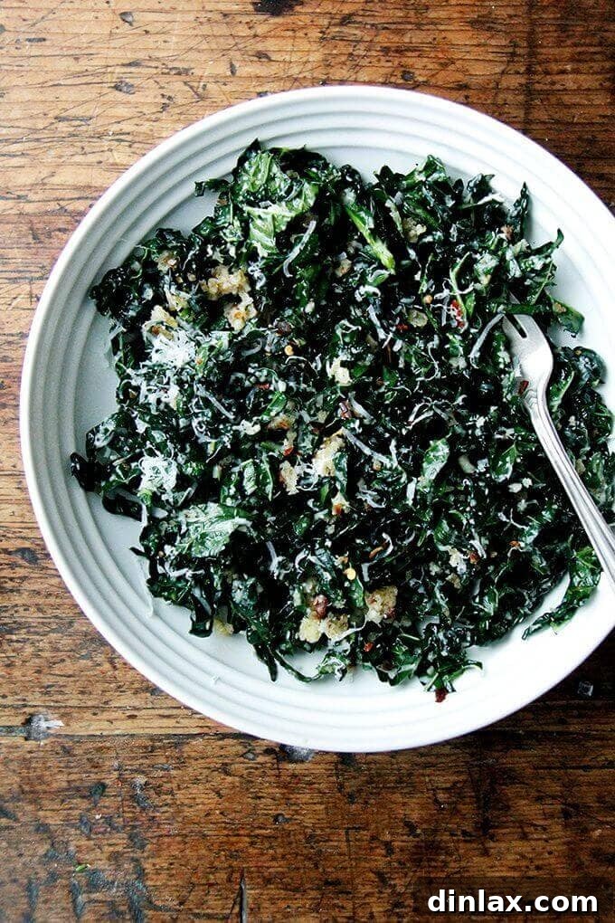 A bowl of fresh kale salad, richly dressed with shallot vinaigrette and topped with toasted breadcrumbs and grated Parmesan cheese, ready to be enjoyed.