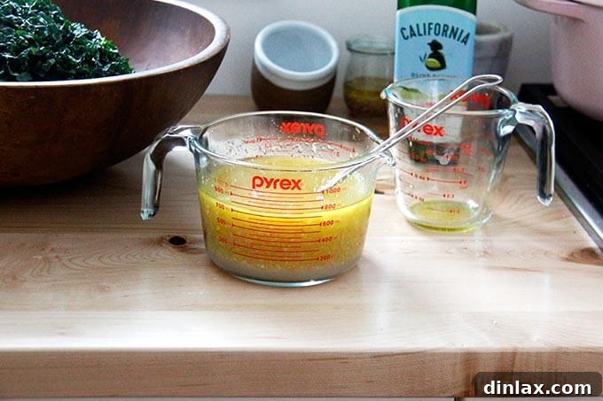 A large batch of shallot vinaigrette, a creamy, emulsified dressing, rests in a clear liquid measuring cup, ready to be used.