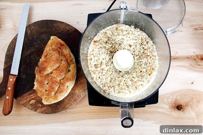 The food processor bowl contains finely whizzed breadcrumbs, transformed from day-old bread, ready for toasting.