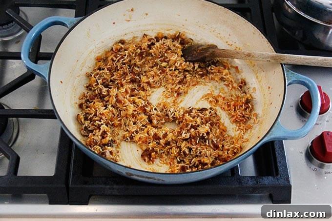 Instant Pot Harissa Rice with Sweet Dates and Zesty Orange 12 A skillet with Moroccan rice being cooked stovetop, with dates and orange zest added and stirred.