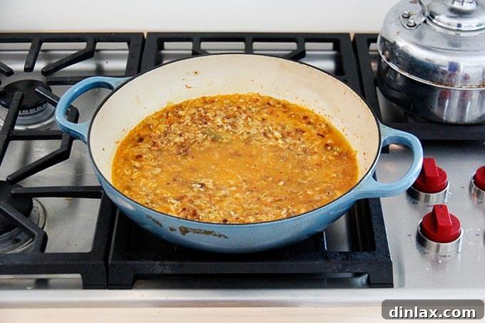 Instant Pot Harissa Rice with Sweet Dates and Zesty Orange 14 Moroccan rice mixture in a skillet, just brought to a simmer and ready to be covered and cooked on low heat, trapping the steam for perfect cooking.