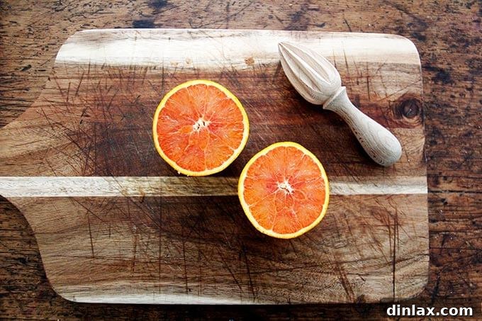 Instant Pot Harissa Rice with Sweet Dates and Zesty Orange 4 A halved fresh orange on a cutting board, highlighting its vibrant color and juicy pulp, ready for zesting and juicing.