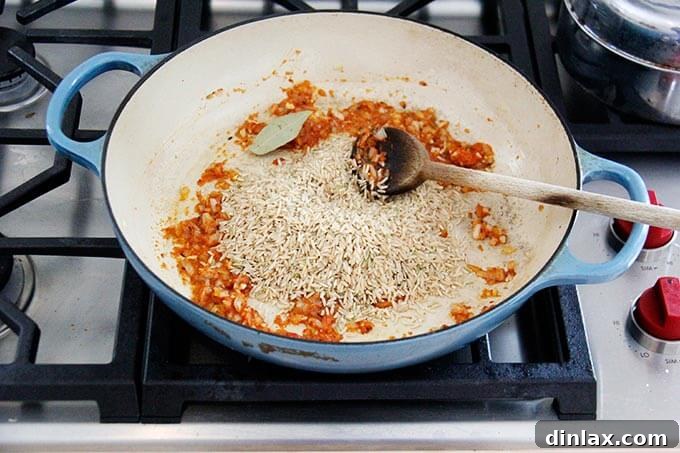 Instant Pot Harissa Rice with Sweet Dates and Zesty Orange 9 Rinsed basmati rice added to the skillet with the sautéed harissa, onion, and garlic mixture, ready to be toasted.