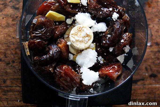 Zesty Lemon Coconut Date Bites 9 A food processor filled with the ingredients to make lemon coconut date balls.