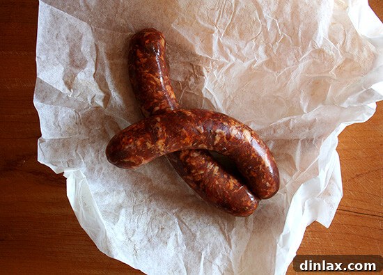 Crumbled hot Italian sausage browning in a sauté pan, releasing its aromatic flavors.