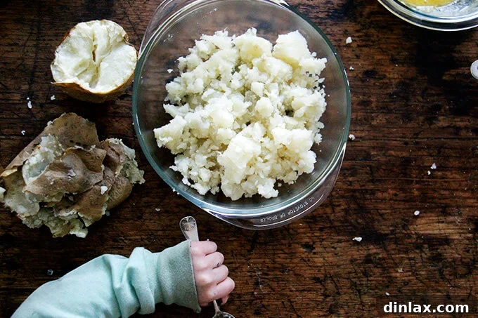 Hands gently pressing gnocchi dough to create the classic ridged shape.