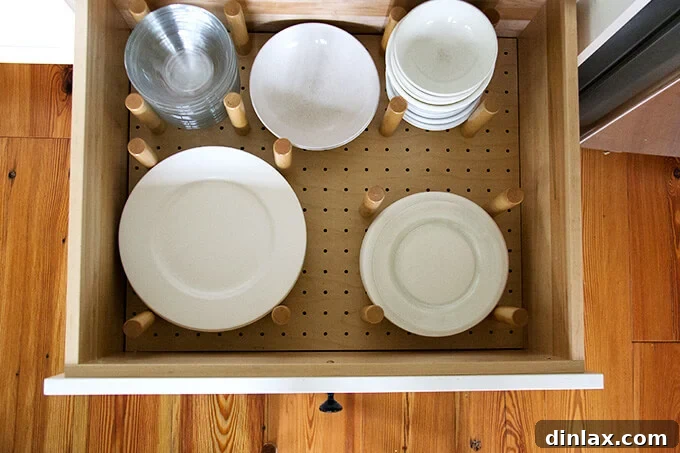 Deep kitchen drawer with adjustable peg dividers, ideal for organizing plates and bowls.