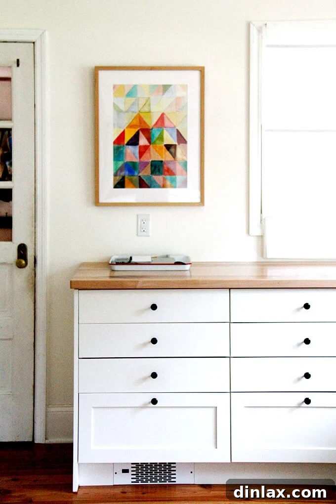 A beautifully framed painting hanging on a light-colored kitchen wall, adding a personal touch.