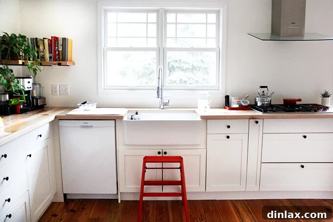 A foldable wooden step stool positioned near the kitchen counter, useful for reaching high cabinets or for children.