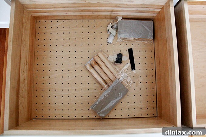 Kitchen drawer with custom pegs for organizing plates and dishes, demonstrating smart storage