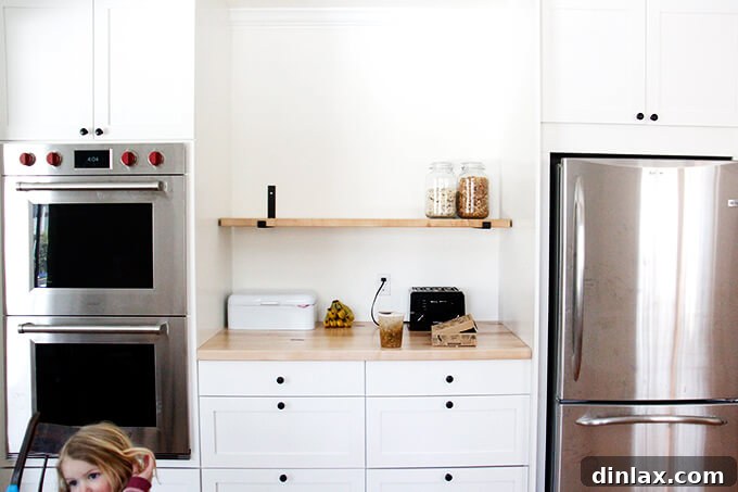 Kitchen shelves being installed, adding both functional storage and decorative display space
