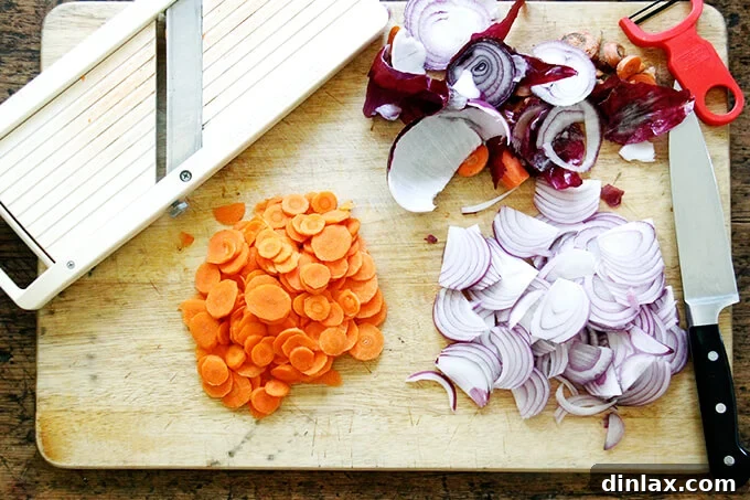 Sliced carrot and onion aside a mandoline. 