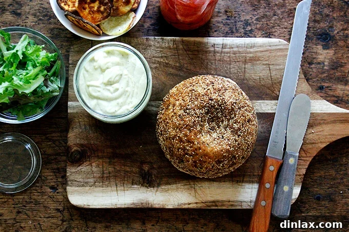 An overhead shot showing all the prepared components for making the sweet potato sandwiches: bread, roasted sweet potatoes, aioli, pickled vegetables, lettuce, and goat cheese.