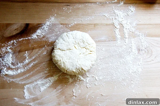 Rustic Rhubarb Frangipane Galette 14 A pristine, lightly floured wooden board serving as a workspace, with a round of expertly rolled pastry dough positioned centrally.