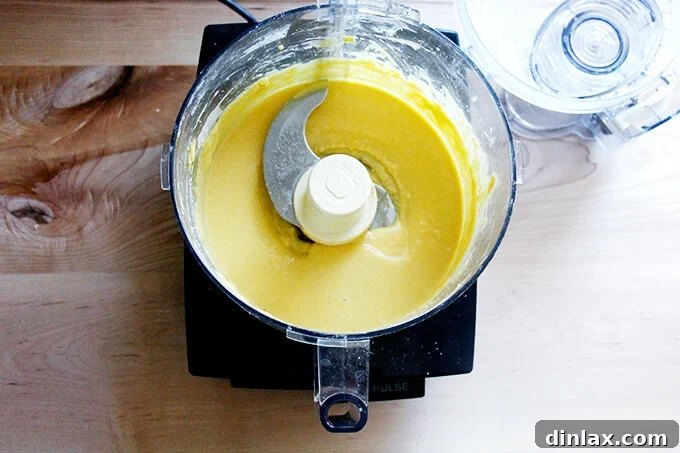 Rustic Rhubarb Frangipane Galette 21 The food processor bowl now holds a perfectly smooth and pale frangipane mixture, indicating it's fully blended.