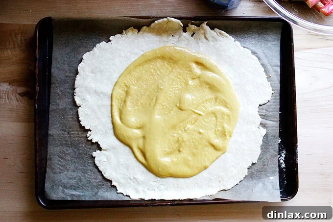 Rustic Rhubarb Frangipane Galette 22 Creamy frangipane elegantly spread across the center of the rolled-out pastry dough, leaving a clear border.