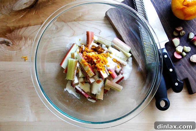 Rustic Rhubarb Frangipane Galette 4 A glass bowl filled with chopped rhubarb, grated orange zest, and granulated sugar, mixed thoroughly.