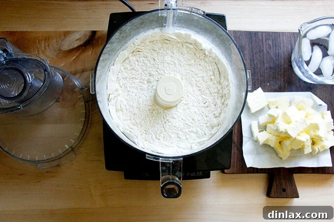Rustic Rhubarb Frangipane Galette 6 Close-up view inside a food processor bowl, showing flour, sugar, and salt after being pulsed together.