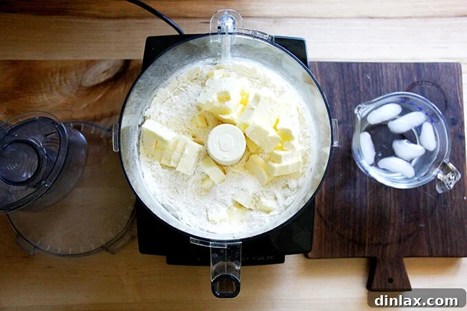 Rustic Rhubarb Frangipane Galette 7 A food processor bowl with flour mixture and cold butter cubes, having been pulsed a few times to create pea-sized butter chunks.