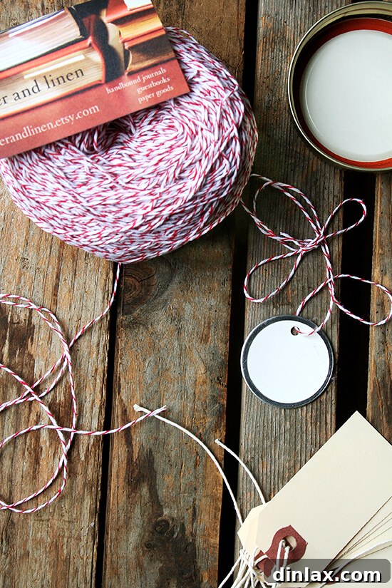 Baker's twine in red and white, elegantly tied around various holiday items like a gift tag and a jar, symbolizing festive homemade touches.