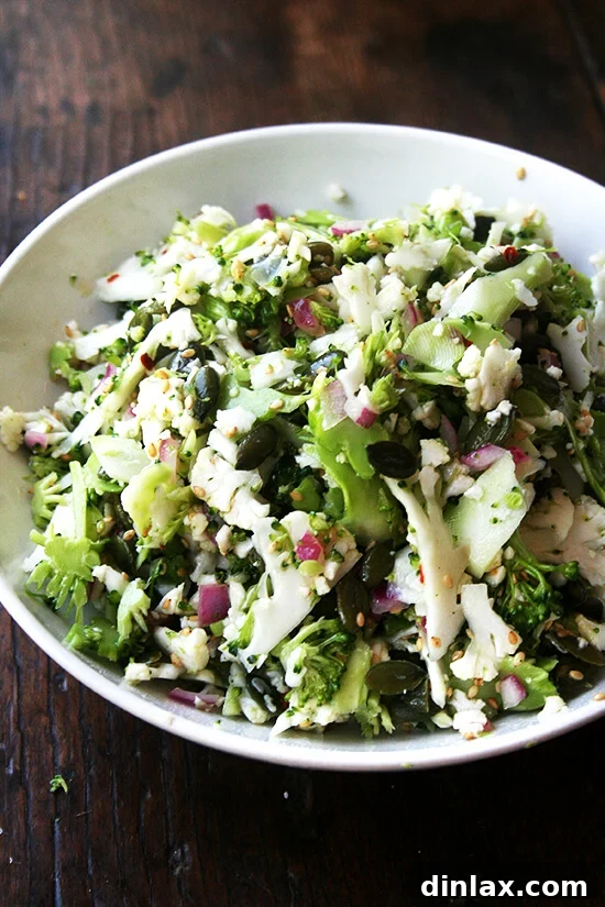 Crunchy raw cauliflower, broccoli, and pepita salad, suitable for various dietary needs.