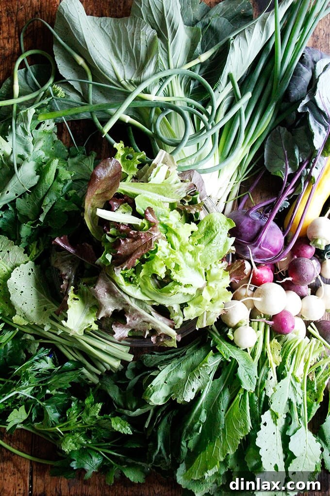 A beautiful array of fresh produce from a CSA farm share, including leafy greens, radishes, and turnips