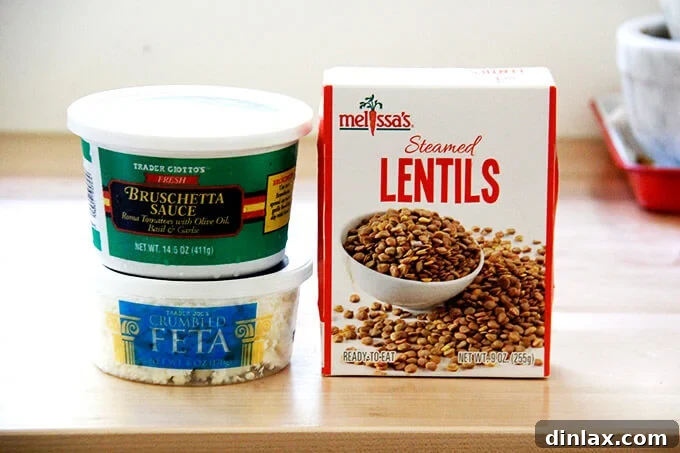 The three essential ingredients for Trader Joe's lentil salad: a tub of feta, a box of cooked lentils, and a tub of bruschetta sauce.