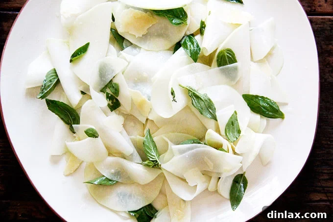 The finished Shaved Kohlrabi Salad with basil and parmesan, elegantly arranged on a platter, ready to be served. A delicious and healthy dish.