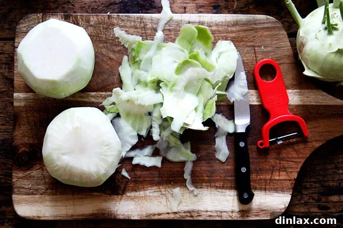 Peeled kohlrabi bulbs ready for slicing, showing the smooth, light green interior. A crucial step for a tender salad.