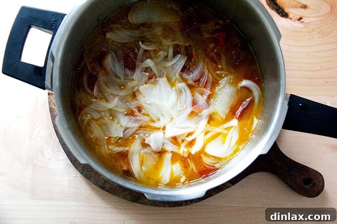Puréeing the tomato sauce with an immersion blender.