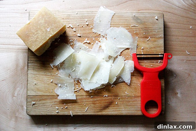 Shaving Parmigiano Reggiano over the baked involtini.