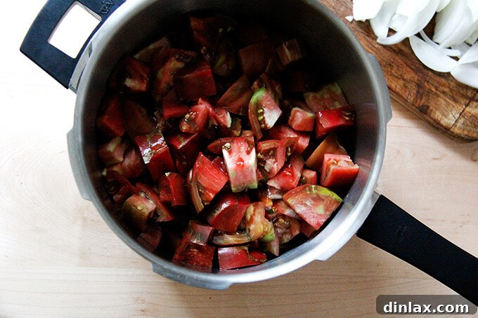Onions, salt, and butter added to the tomatoes in the pressure cooker.