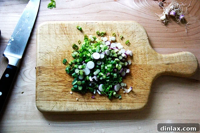 A board filled with sliced scallions.